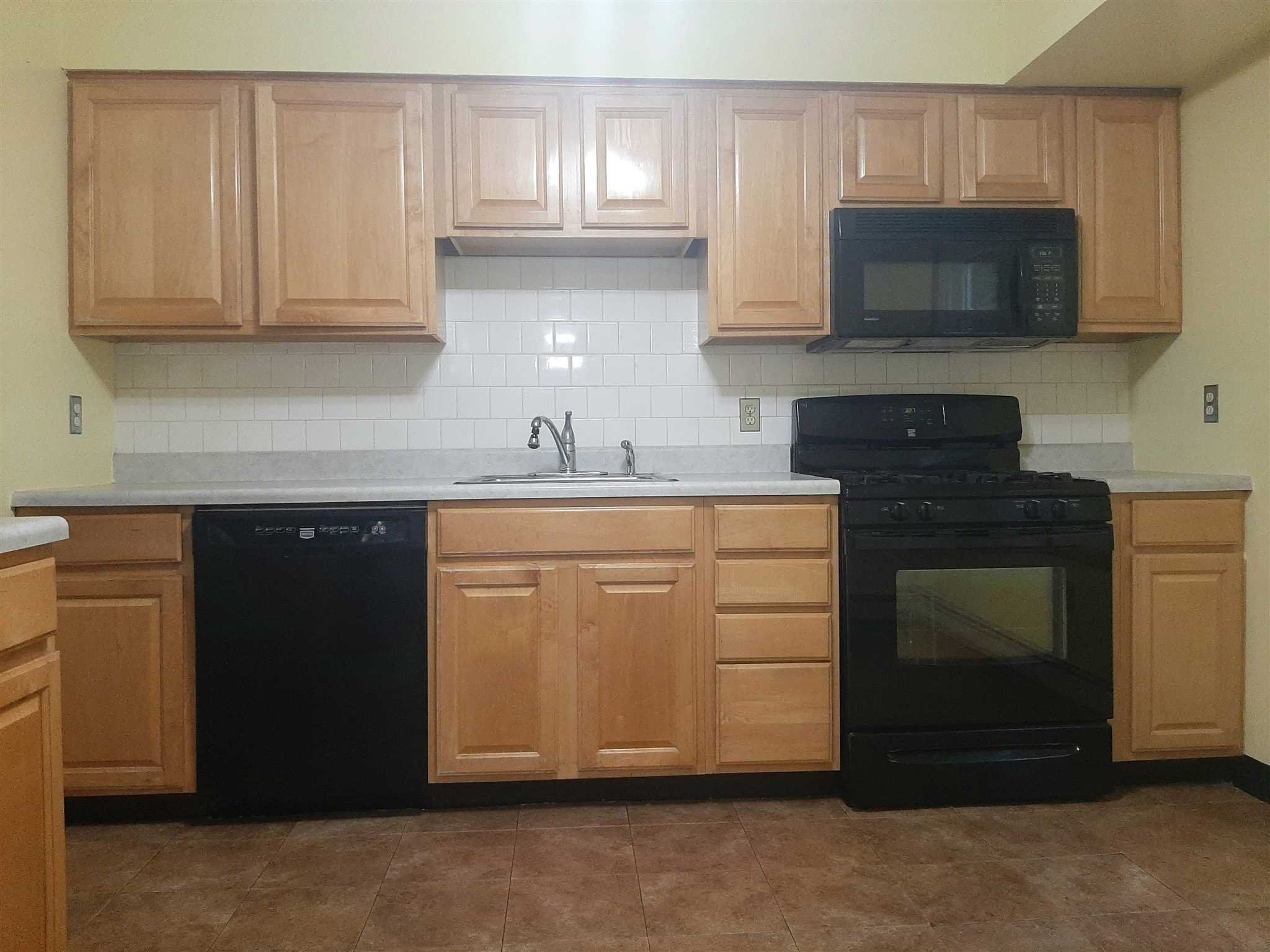 97 Sutton Park Road Poughkeepsie, NY 12603 - Photo 6 of 20 a kitchen with cabinets stainless steel appliances and a sink