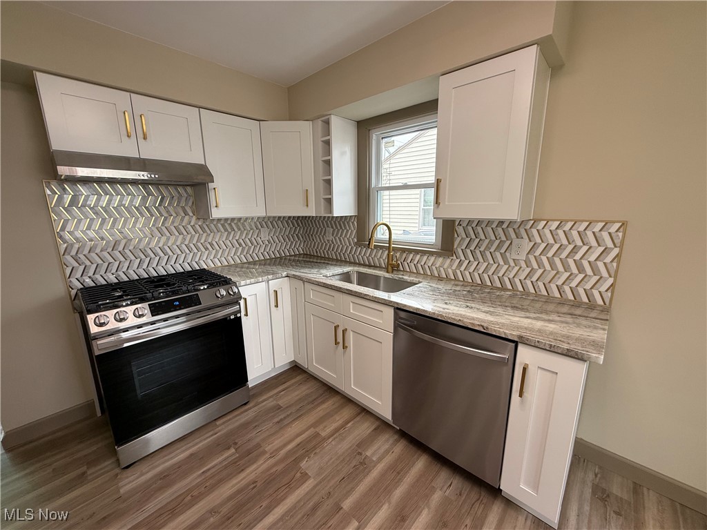 9417 Alexander Road Garfield Heights, OH 44125 - Photo 6 of 38 Kitchen with open shelves, white cabinetry, wood finished floors, a sink, and stainless steel appliances
