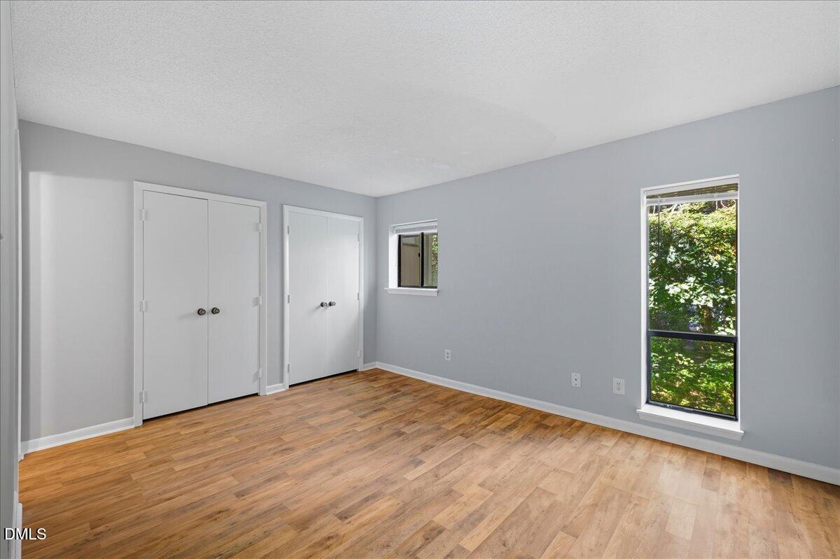 627 Pine Ridge Place Raleigh, NC 27609 - Photo 13 of 19 a view of an empty room with wooden floor and a window