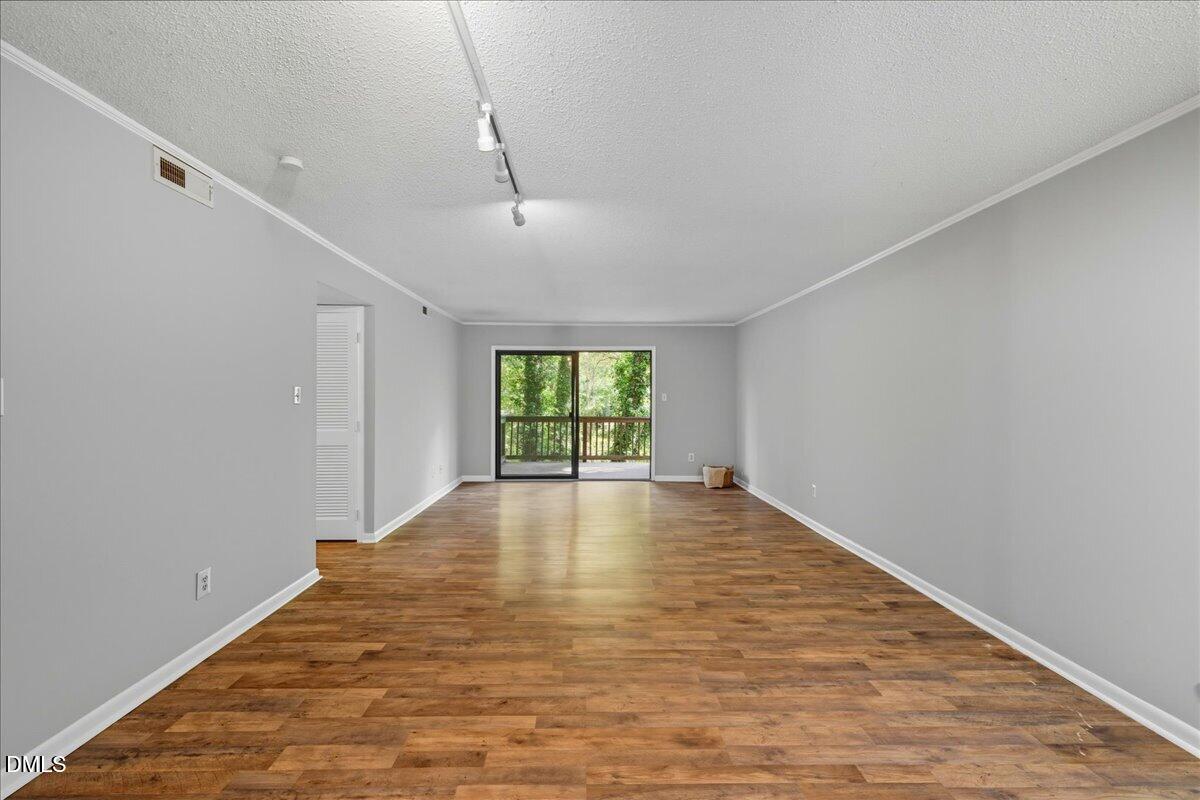 627 Pine Ridge Place Raleigh, NC 27609 - Photo 3 of 19 a view of empty room with wooden floor and fan