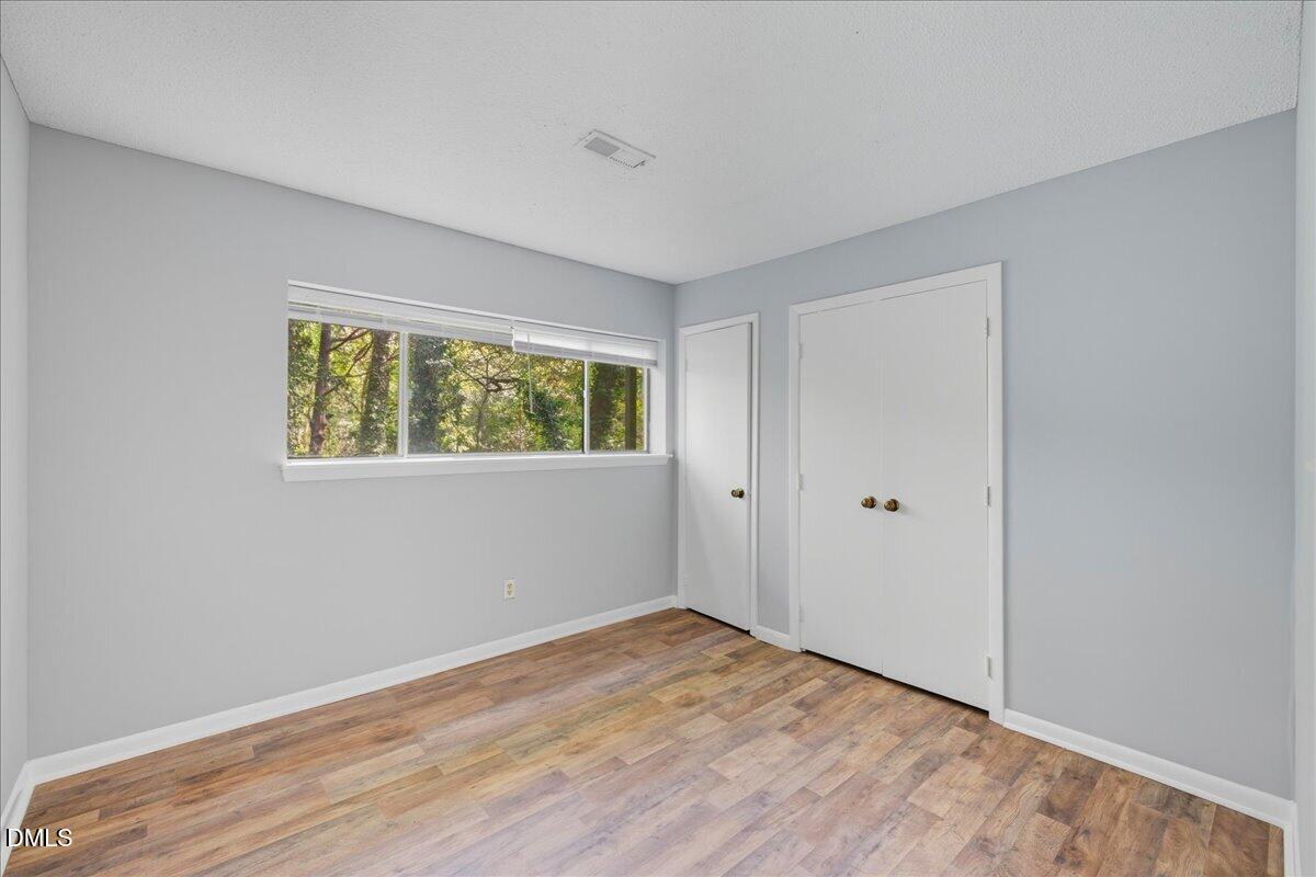 627 Pine Ridge Place Raleigh, NC 27609 - Photo 10 of 19 a view of an empty room with wooden floor and a window