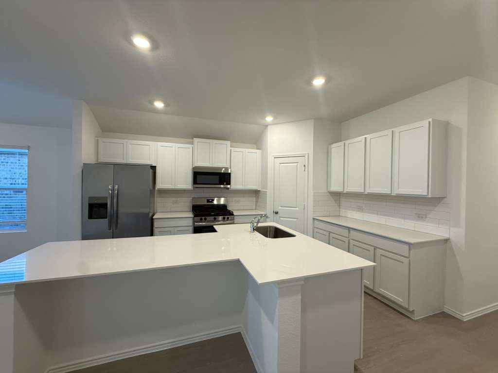 591 Sormonne Loop Kyle, TX 78640 - Photo 12 of 40 a kitchen with stainless steel appliances a refrigerator sink and microwave