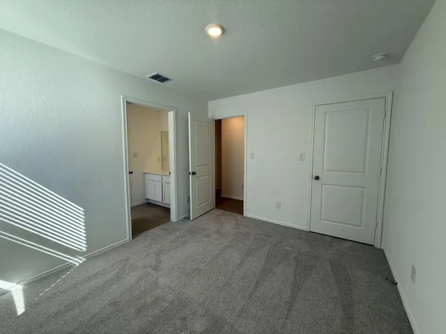 an empty room with closet and a bathroom