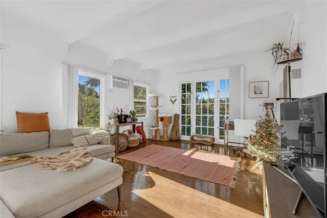 a living room with furniture a floor to ceiling window and potted plant