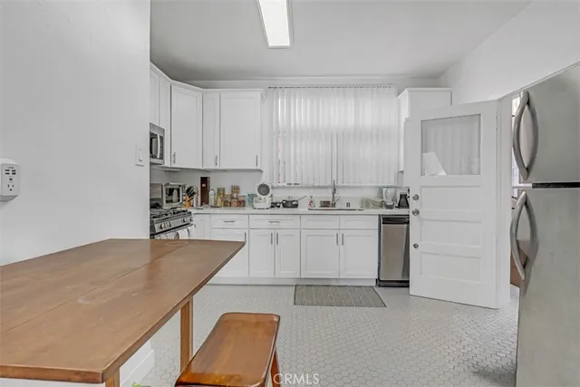 a kitchen with white cabinets and refrigerator
