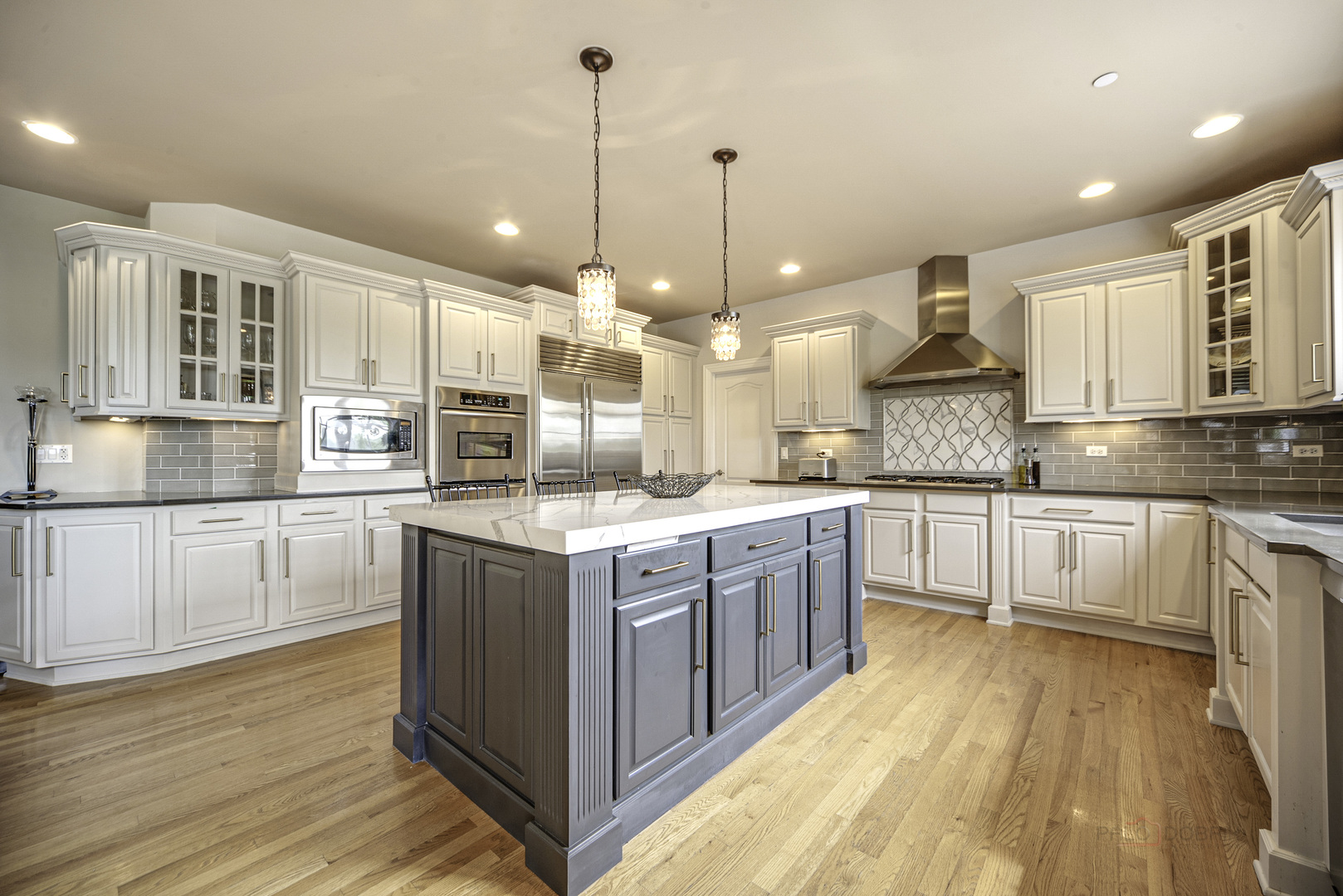 4907 Clover Court Long Grove, IL 60047 - Photo 25 of 67 a large kitchen with stainless steel appliances granite countertop a stove a sink and white cabinets with wooden floor