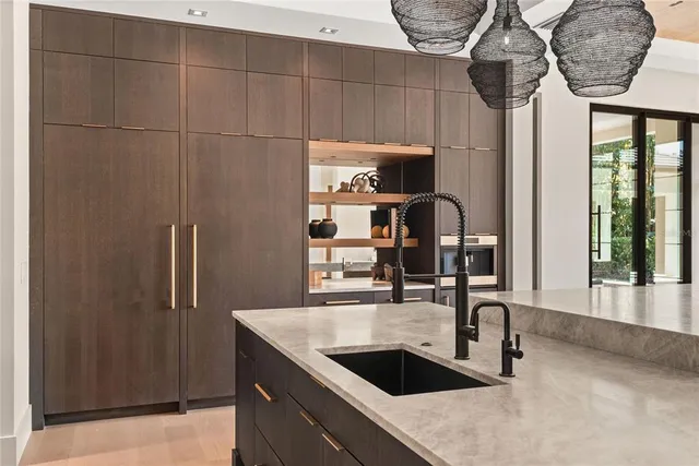 a view of a patio with table and chairs potted plants and floor to ceiling window