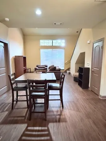 a dining room with furniture a rug and wooden floor