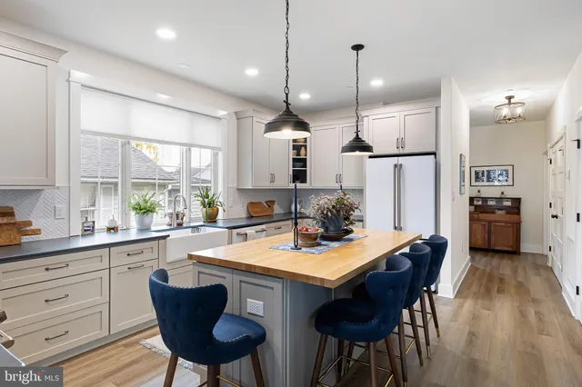 a kitchen with kitchen island granite countertop a stove and a wooden floor
