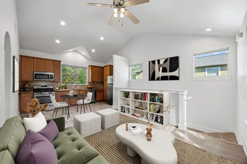 a living room with furniture kitchen view and a window