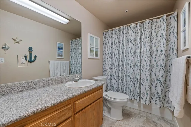 a bathroom with a granite countertop sink toilet a large mirror a shower and vanity