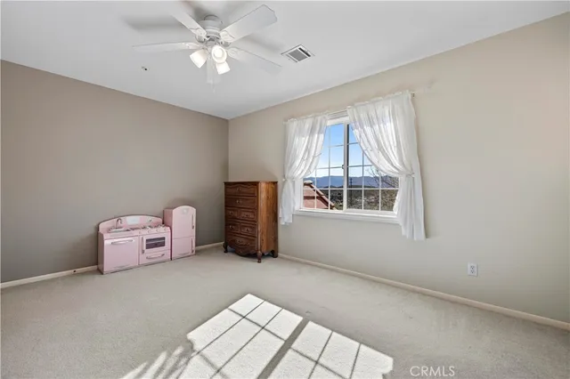 a view of a lush green field with mountains in the background