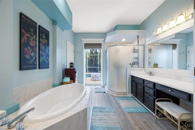 a spacious bathroom with a tub double vanity and a shower