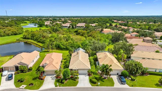 an aerial view of residential houses with outdoor space and trees