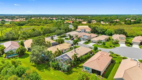 an aerial view of residential houses with outdoor space and trees