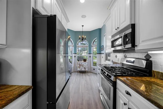 a kitchen with stainless steel appliances granite countertop a stove and a refrigerator