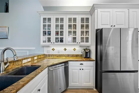 a kitchen with stainless steel appliances granite countertop a refrigerator and a sink