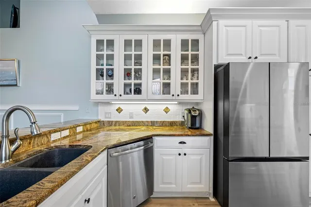 a kitchen with stainless steel appliances granite countertop a refrigerator and a sink