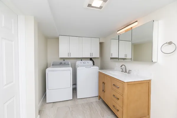 a utility room with cabinets washer and dryer