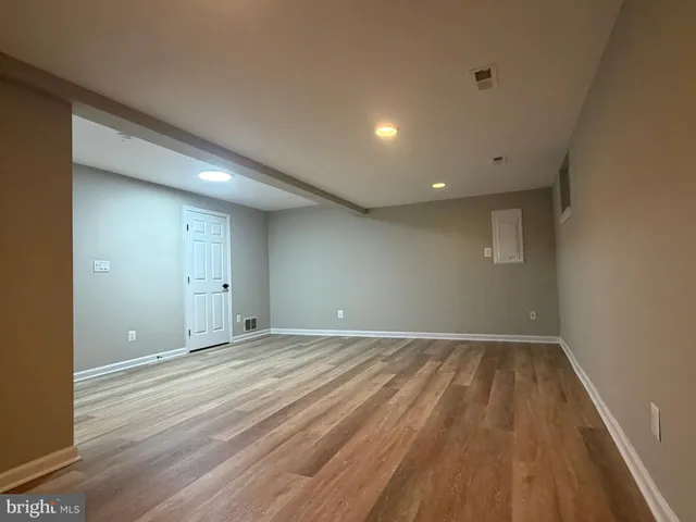 an empty room with wooden floor and white walls