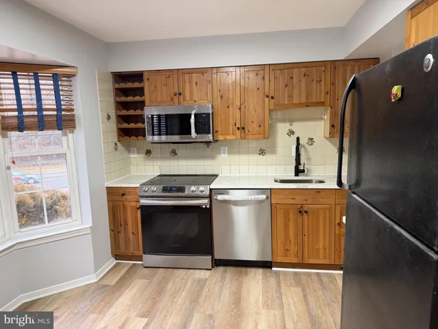 a kitchen with stainless steel appliances granite countertop a refrigerator a stove a sink and a microwave