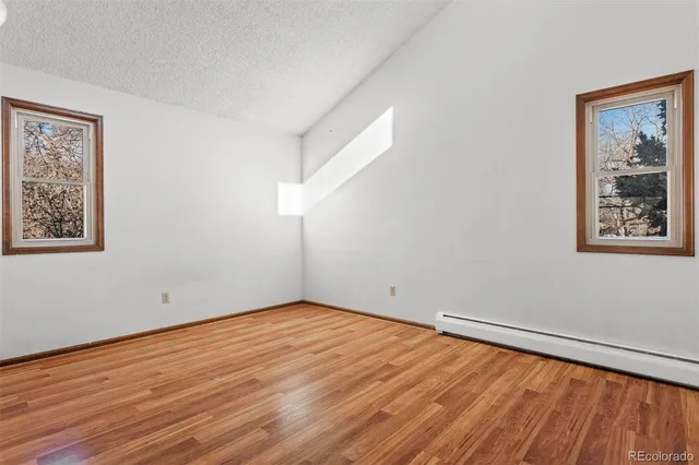 a view of empty room with wooden floor