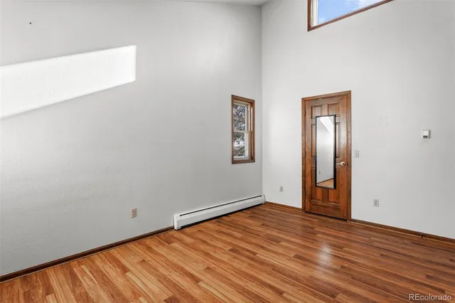 a view of an empty room with wooden floor