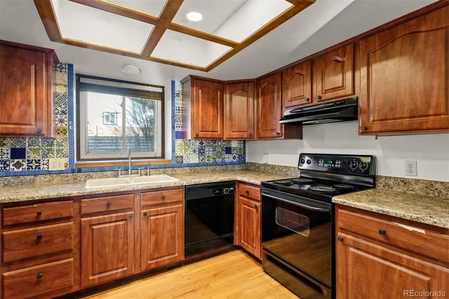 a kitchen with stainless steel appliances granite countertop wooden cabinets stove top oven and sink