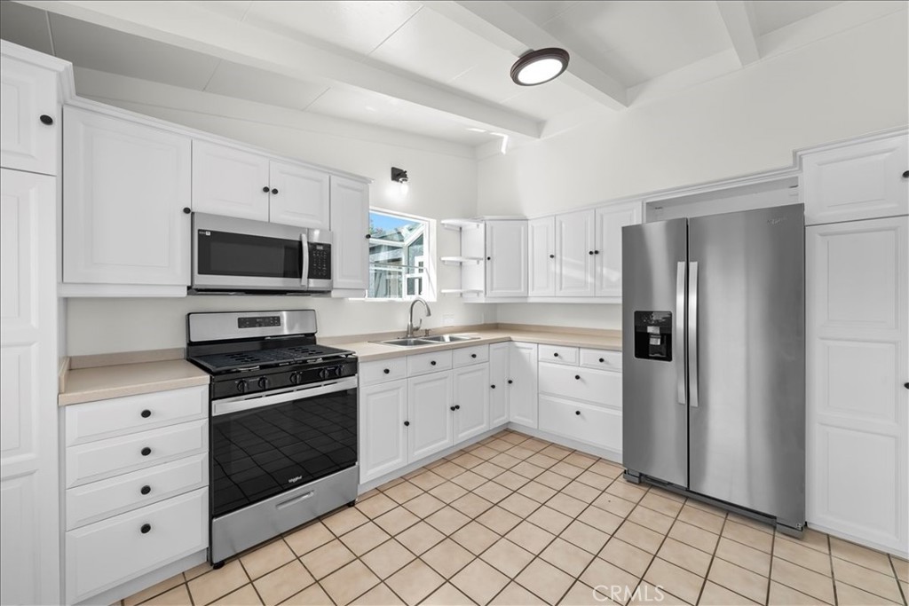 10802 Deshire Place Culver City, CA 90230 - Photo 23 of 50 a kitchen with white cabinets and appliances