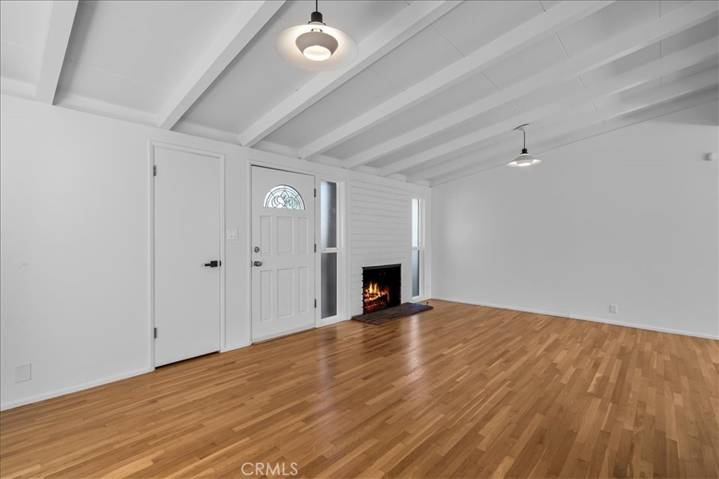 10802 Deshire Place Culver City, CA 90230 - Photo 10 of 50 a view of an empty room with wooden floor and a fireplace