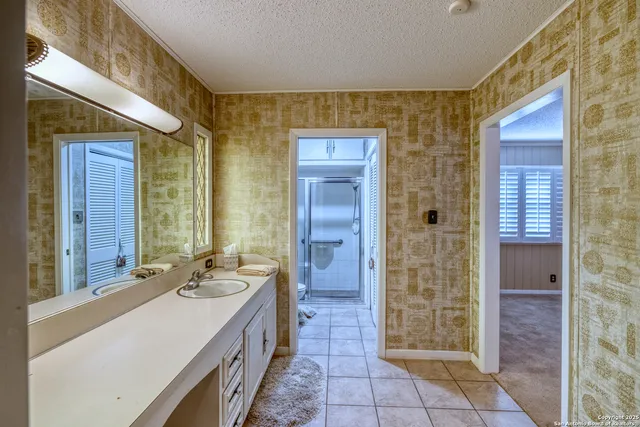 a bathroom with a granite countertop sink and a mirror