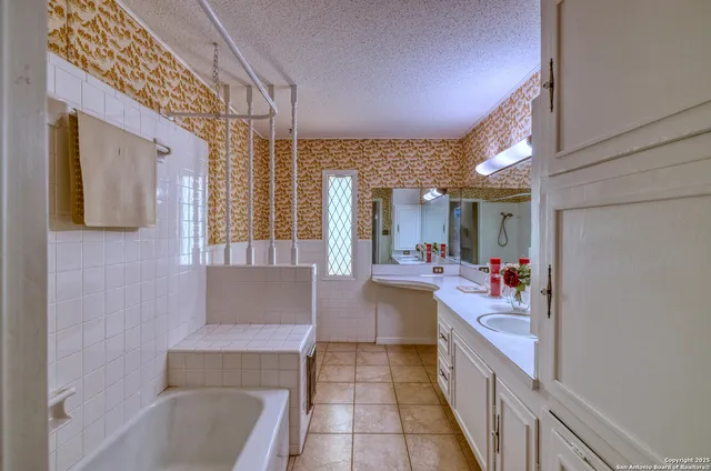 a bathroom with a granite countertop sink mirror and a bathtub