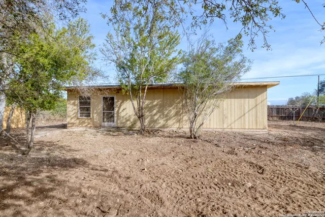 a backyard of a house with barbeque oven table and chairs