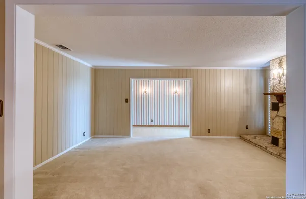 a view of an empty room with a fireplace and a window