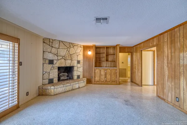 a view of a livingroom with a fireplace and window