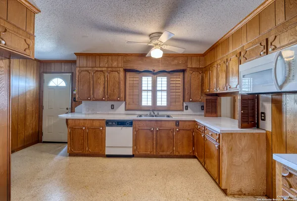 a kitchen with stainless steel appliances granite countertop a refrigerator a stove and a sink with cabinets