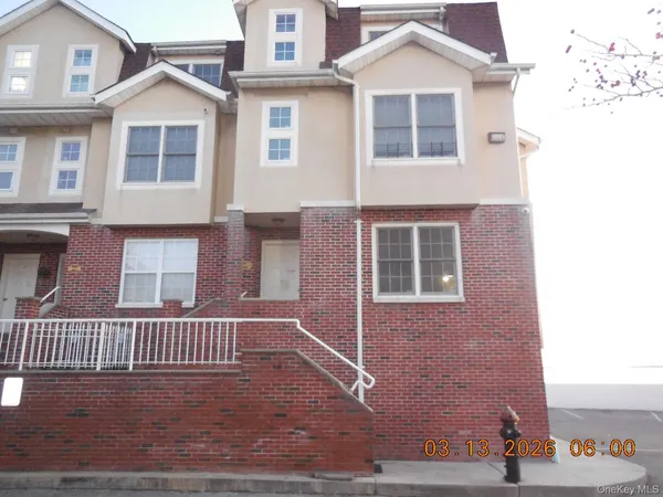 a view of a brick house with windows and a yard