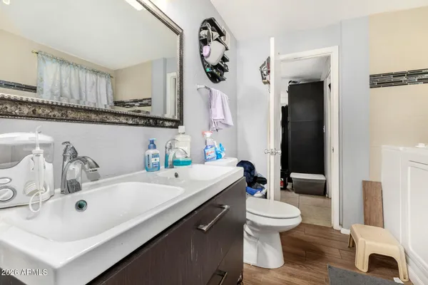 a bathroom with a sink a toilet and a mirror