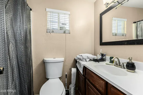 a bathroom with a sink a toilet and a mirror