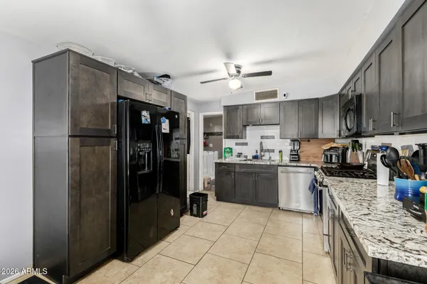 a kitchen with stainless steel appliances granite countertop a refrigerator stove top oven and sink