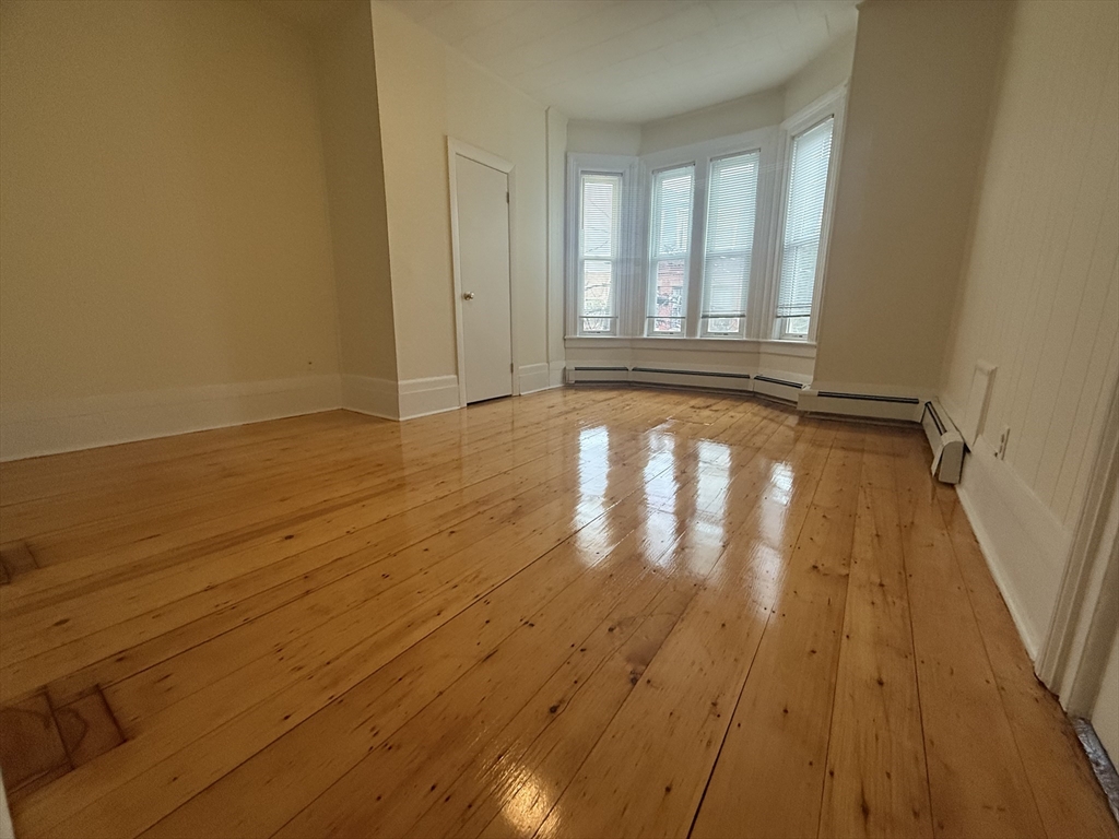 48 Florence Street, Unit 2 Somerville, MA 02145 - Photo 1 of 11 a view of an empty room with wooden floor and a window