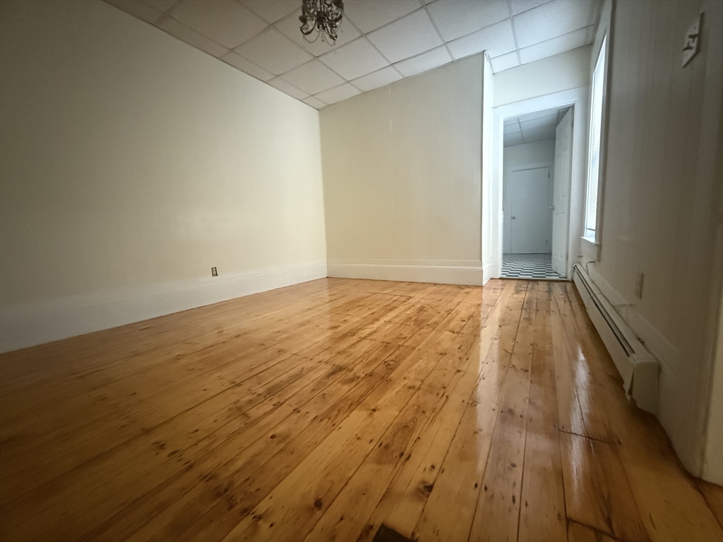48 Florence Street, Unit 2 Somerville, MA 02145 - Photo 6 of 11 an empty room with wooden floor and fan