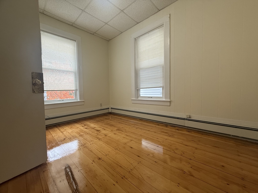 48 Florence Street, Unit 2 Somerville, MA 02145 - Photo 8 of 11 an empty room with wooden floor and windows