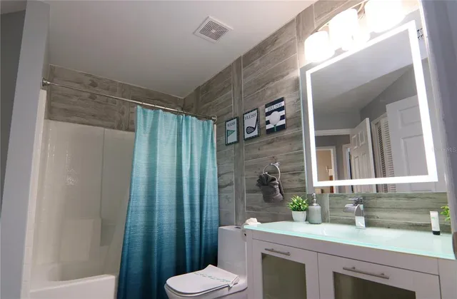 a bedroom with a bed a couch and a ceiling fan