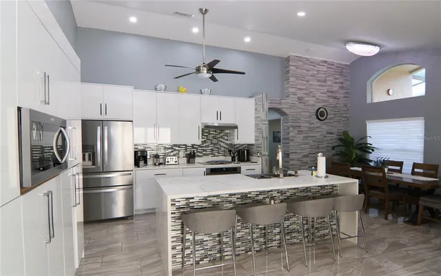 a kitchen with stainless steel appliances granite countertop a stove refrigerator and cabinets