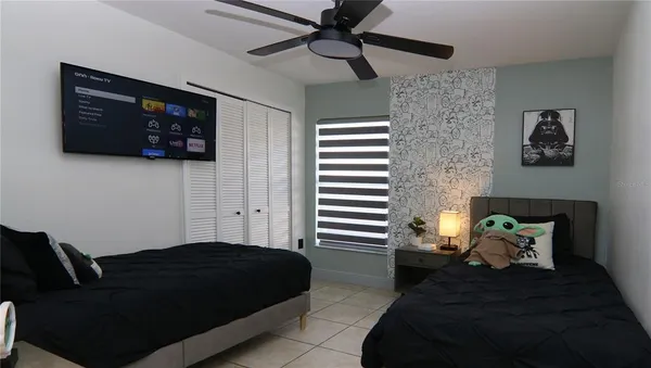 a bedroom with a bed and a lamp on dresser