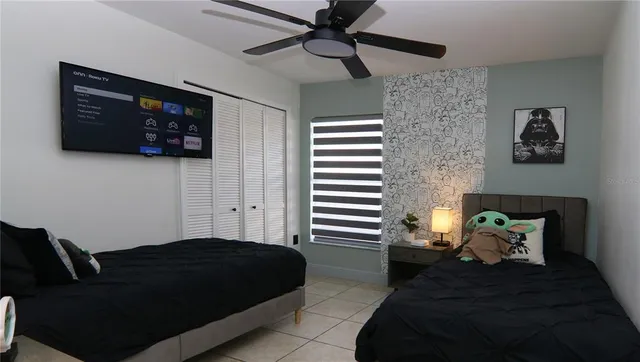 a bedroom with a bed and a lamp on dresser