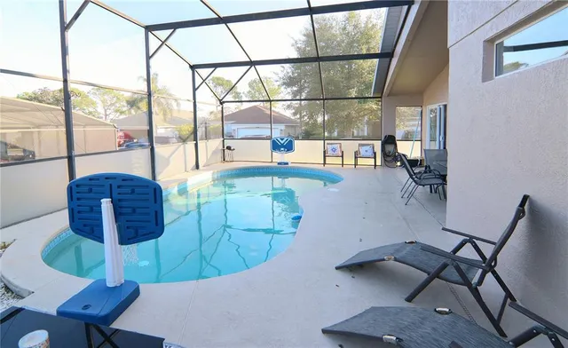 a view of a dining room with furniture one side kitchen view and a chandelier