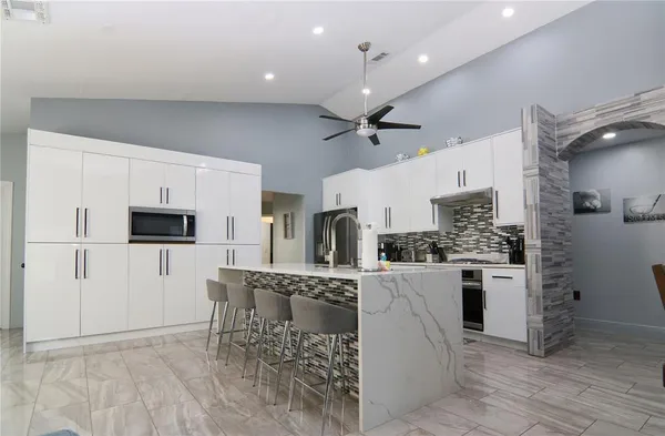 a kitchen with stainless steel appliances kitchen island granite countertop a refrigerator and a stove top oven