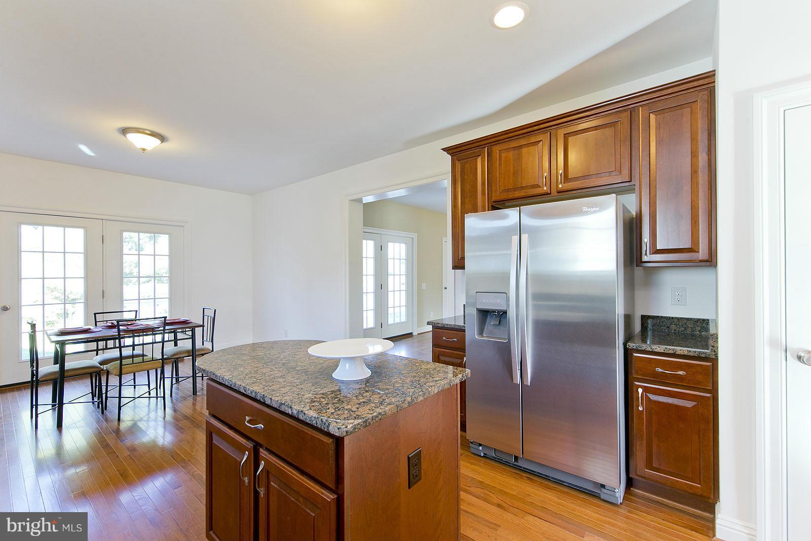 481 Bowling View Road Front Royal, VA 22630 - Photo 10 of 30 a kitchen with stainless steel appliances granite countertop a refrigerator a stove and a dining table with wooden floor